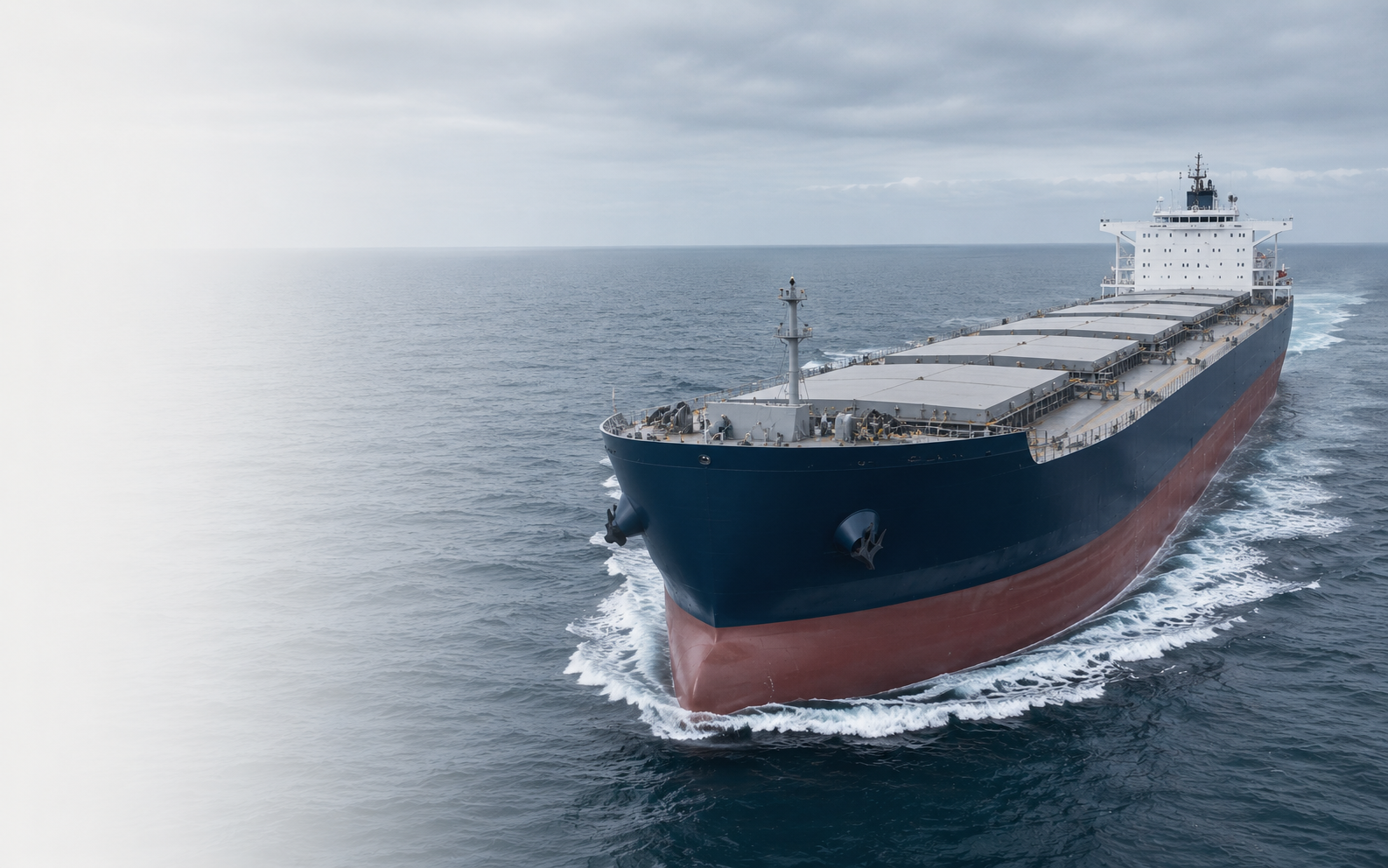 Modern blue Kamsarmax bulk carrier sailing in ballast at sea